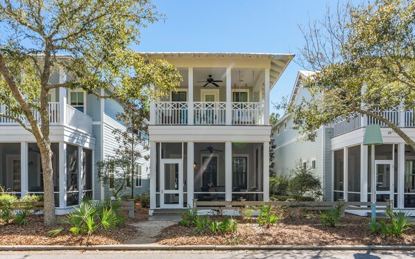 A two-story building with a balcony, large windows, and a porch area. - Upscale Watercolor Home + Golf Cart, Bikes & Pools (Santa Rosa Beach)