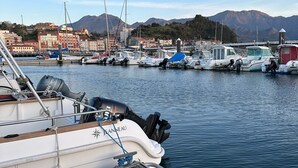 A marina with boats docked, a wooden dock, and a mountainous backdrop. - Socaire Apartment in Ribadesella – Central, Renovated, Near the Beach (Ribadesella)