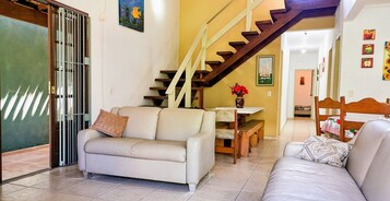 A living room with a sofa, a coffee table, and a staircase.