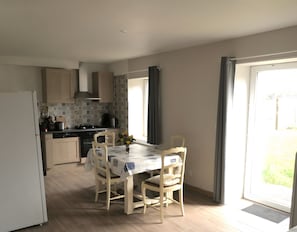 Une cuisine moderne avec une table à manger, des chaises et un réfrigérateur.