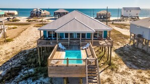 Ein Strandhaus mit Pool, mehreren Terrassen und Meerblick.