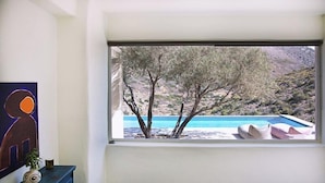 Ein Zimmer mit einem großen Fenster mit Blick auf einen Pool und Bäume.