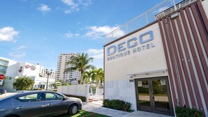 A Deco Boutique Hotel with a modern facade, a gated entrance, and a parking area with a car. - Deco Boutique Hotel (Fort Lauderdale)