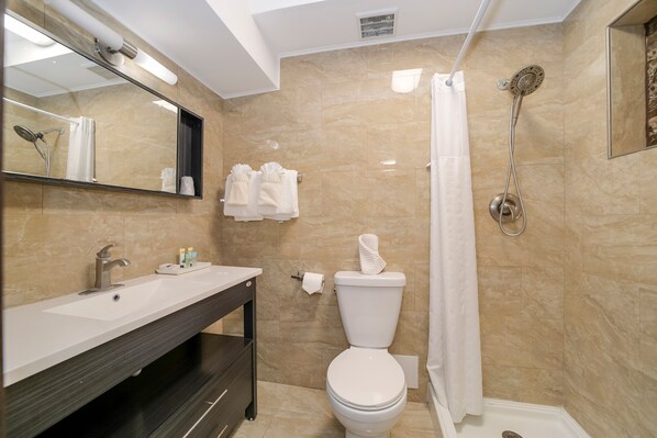 Un baño moderno con lavamanos, inodoro y ducha.