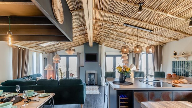 A modern living space with a high ceiling, a dining area, and a kitchen. - 2 Bed in Pensilva (oc-s30446) (Pensilva)