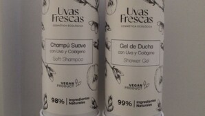 Due bottiglie di prodotti Uvas Frescas: una di shampoo e una di bagnoschiuma, entrambi con etichetta vegana e con il 98-99% di ingredienti naturali.