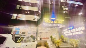 The exterior of the Eagle Grand Hotel with a modern design, featuring a prominent entrance and a staircase leading to the lobby. - Hotel Sm Eagle Grand Airport Zone Hyd (Hyderabad)