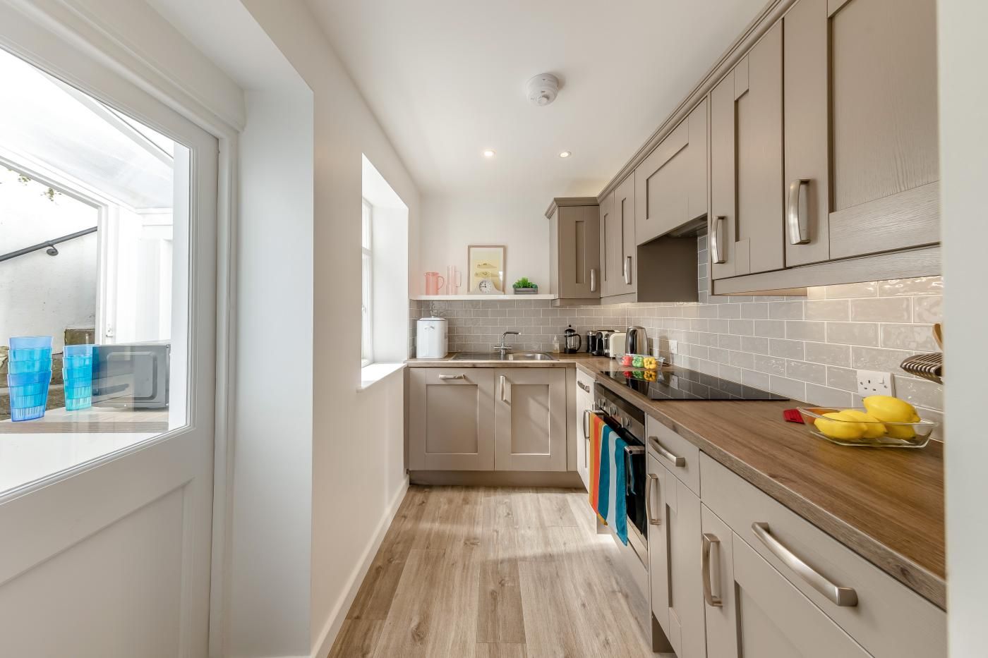 A modern kitchen with wooden cabinets, a countertop, and a window.