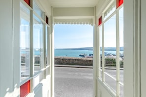 Ein Balkon mit Blick auf das Meer und einer Steinmauer.