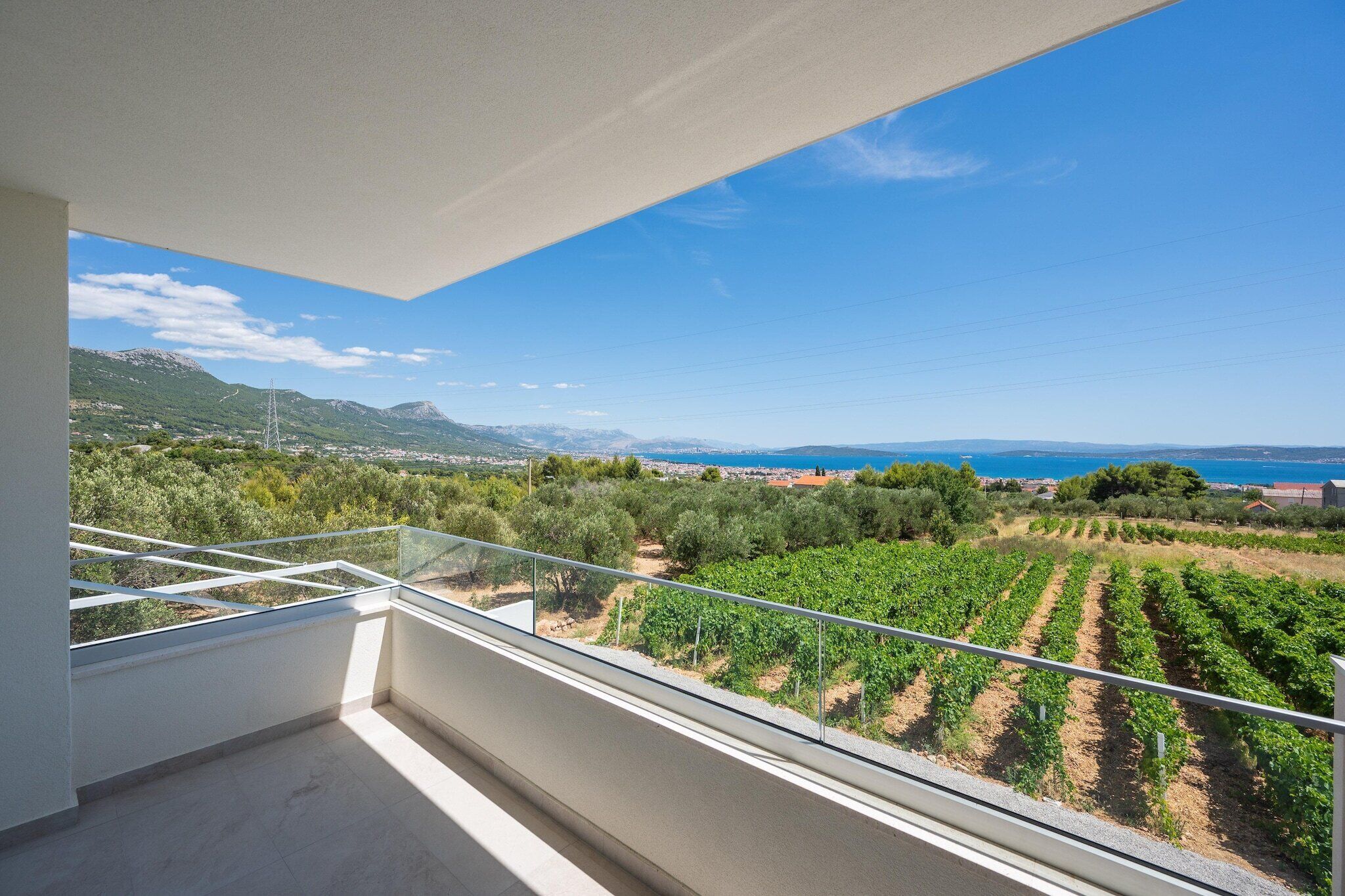 A balcony with a clear view of vineyards and mountains.