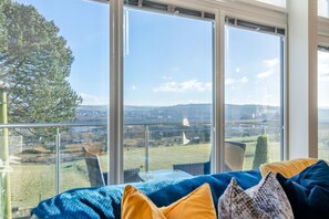 A room with a large window overlooking a landscape, a sofa with cushions, and a glass railing. - 2 Bed in Barrowford (oc-w30592) (Barrowford)