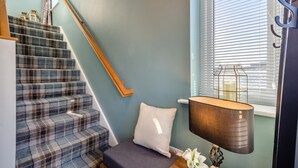 A staircase with a plaid carpet, a white cushion, a lamp, and a window with blinds. - 2 Bed in Barrowford (oc-w30592) (Barrowford)