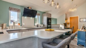 A modern kitchen with a large island, built-in appliances, and pendant lighting. - 2 Bed in Barrowford (oc-w30592) (Barrowford)