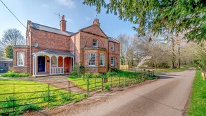 A two-story brick house with a porch and a fenced garden. - 2 Bed in Southwell (oc-n30605) (Southwell)