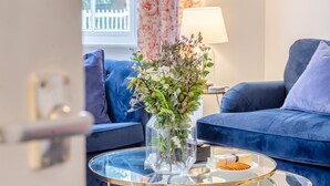 A living room with a glass coffee table, a floral arrangement, and a plate of snacks. - 2 Bed in Southwell (oc-n30605) (Southwell)