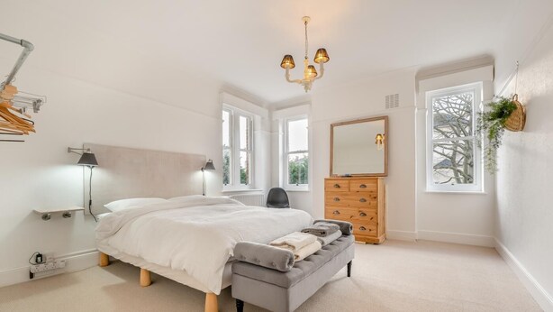 A bedroom with a bed, bedside lamps, a dresser, a mirror, and a window with a view. - 2 Bed in Eastbourne (oc-b30385) (Eastbourne)