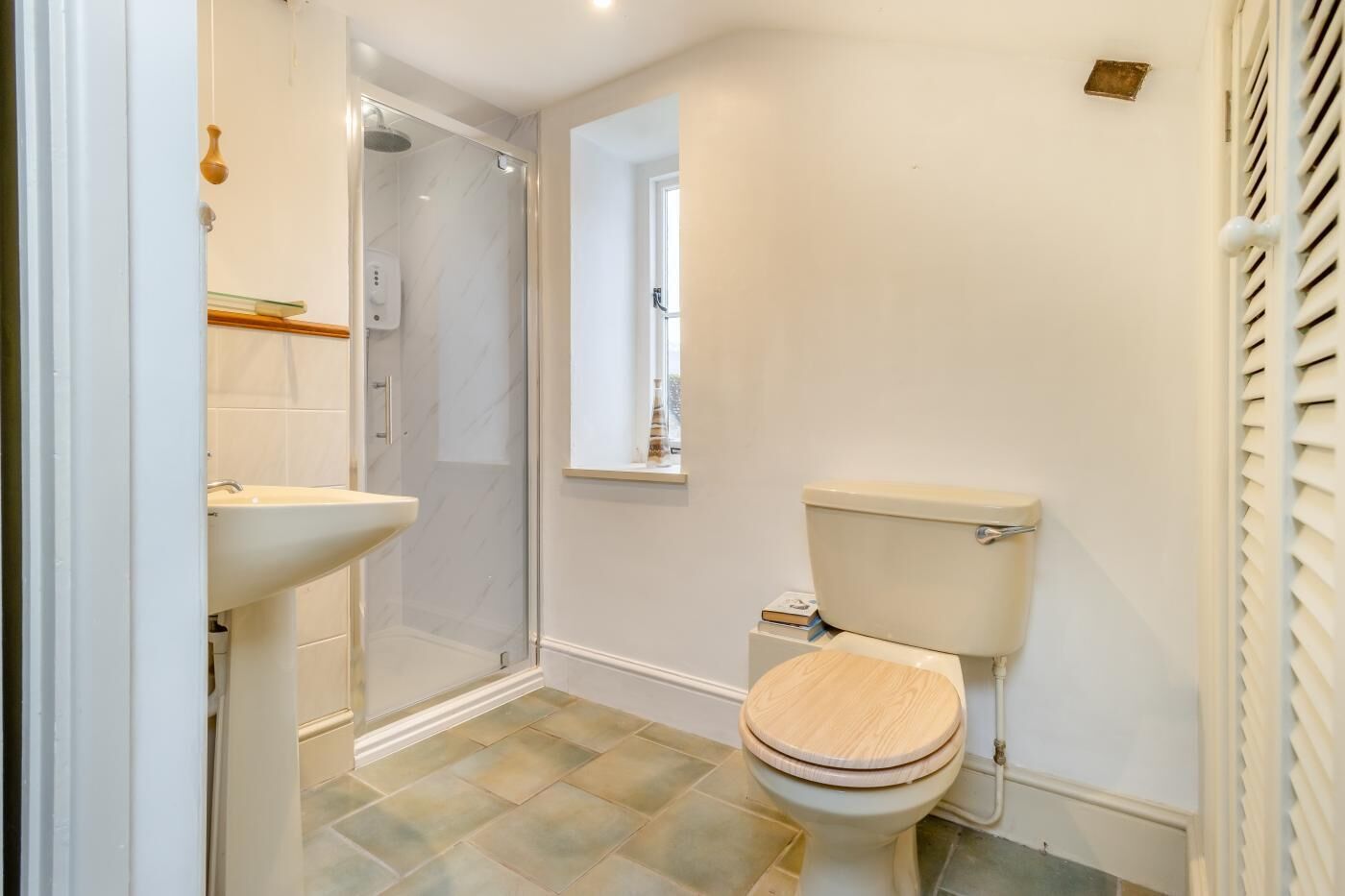 Une salle de bain avec douche, toilettes et lavabo.