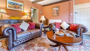 A furnished living room with a sofa, armchairs, a coffee table, and a patterned rug. - 6 Bed in Lower Chapel (oc-c30673) (Lower Chapel)