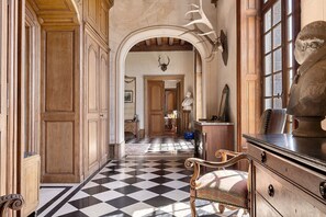 A hallway with a checkered floor, wooden paneling, and a statue. - Château du Perray – Comtesse Suite Room with Shared Pool (Saint-Mars-du-Désert)