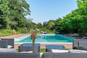 Ein Pool mit LiegestĂŒhlen und einer Blumenkomposition.