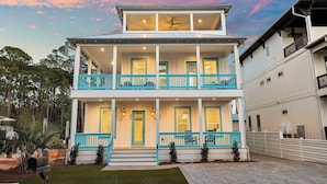 A two-story house with a balcony, a front porch, and a garage. - Ultimate Escape – Spacious Family Home w/ Private Pool & 8 Bikes, 3-Min to Beach (Seagrove Beach)