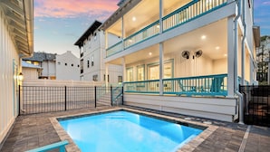 A two-story building with a swimming pool, a balcony, and a gated entrance. - Ultimate Escape – Spacious Family Home w/ Private Pool & 8 Bikes, 3-Min to Beach (Seagrove Beach)