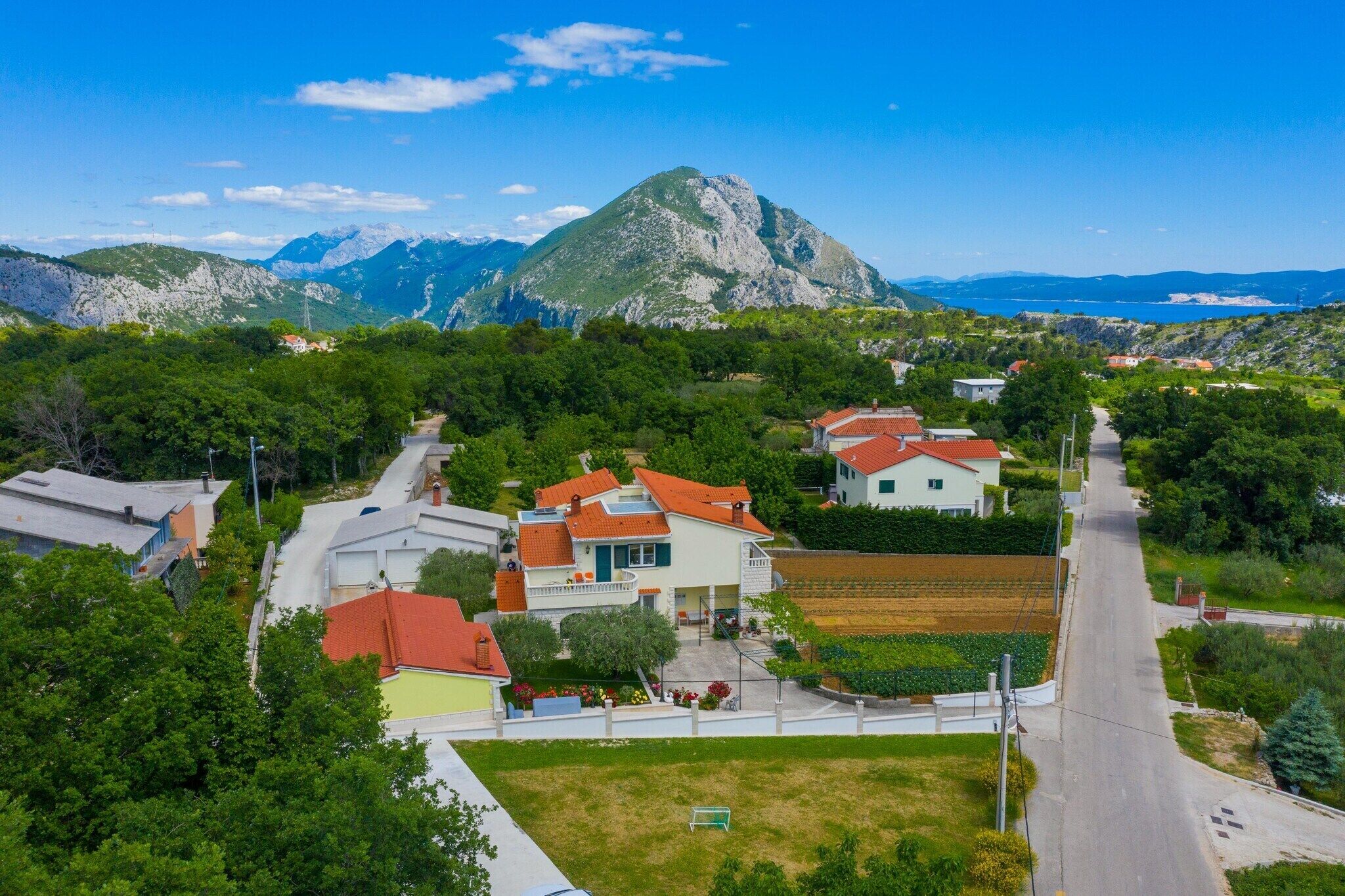 Un quartier résidentiel avec des maisons, une route et une montagne en arrière-plan.
