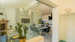 A modern kitchen with a dining area, a glass partition, and a cactus plant. - Tranquil Country Villa in Naklice (županija,)