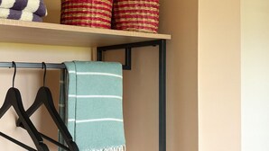 A storage shelf with folded towels and woven baskets. - 2 bedroom apt at blue bay resort / 5 min walk from beach / pool / private patio (Willemstad)