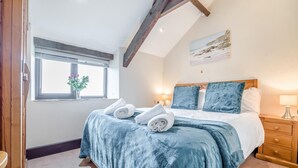 A bedroom with a bed, a window with a view, a nightstand, and a lamp. - 2 Bed in Stibb (oc-m30911) (Stibb)