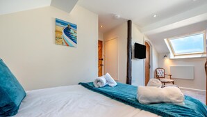 A bedroom with a bed, a painting, a TV, and a window. - 3 Bed in Bude (oc-d30897) (Stibb)