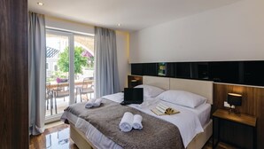 A hotel room with a bed, a laptop, a bedside table, and a view of the outdoors. - Zaton Family Getaway near Adriatic Sea (Zaton)