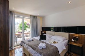 A hotel room with a bed, a laptop, a bedside table, and a view of the outdoors. - Zaton Family Getaway near Adriatic Sea (Zaton)