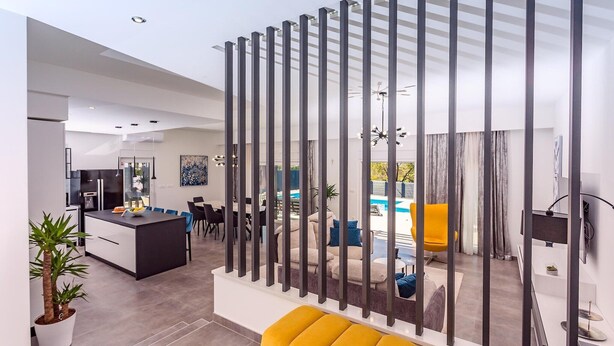 A modern living space with a kitchen, dining area, and a seating area with a pool view. - Luxury Villa Retreat in Šestanovac (Šestanovac)