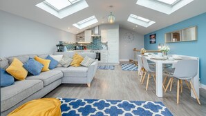 Een modern appartement met dakramen, een woonkamer, een eethoek en een keuken.