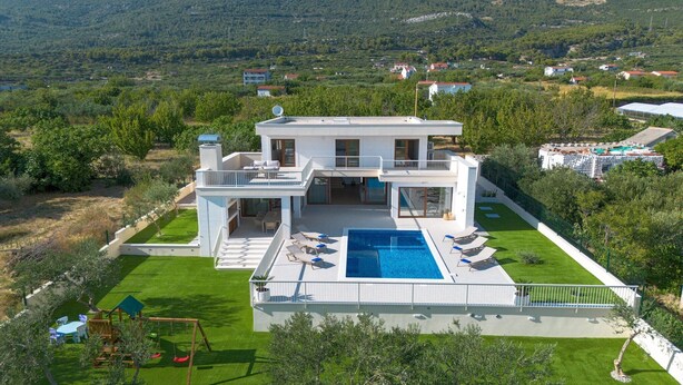A modern two-story house with a swimming pool, a patio, and a view of a mountainous landscape. - Beach Villa with pool near Split (Split-Dalmatia County,)