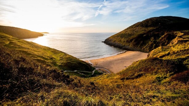 A coastal landscape with a beach, grassy hills, and a clear sky. - 2 Bed in Llwyndafydd (oc-c31062) (Llandysiliogogo)