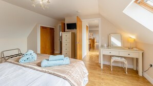 Une chambre à coucher comprenant un lit, un bureau, une chaise, une armoire et un téléviseur.