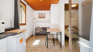 Une cuisine compacte avec un plafond en bois, une table à manger, un canapé et une vue sur l’extérieur.