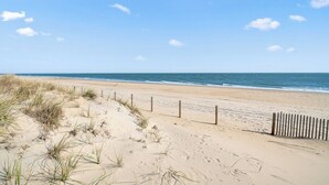 Ein Strand mit einer Holzlattenverkleidung und Dünen.