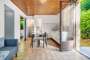 Een moderne keuken met een eethoek, een bank en een schuifdeur naar een tuin.