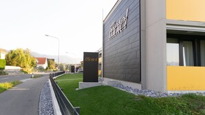 Ein modernes Hotel mit auffälligem Schild, befestigter Auffahrt und gepflegtem Rasen.