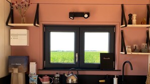 A kitchen with a window, a sink, and a stove. - Tiny house in the heart of the countryside, 1 hour from Paris - calm and a change of scenery guaranteed! (Brégy)