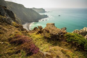 A coastal landscape with rocky cliffs, a beach, and the ocean. - 1 Bed in Kilkhampton (oc-j31131) (Pancrasweek)