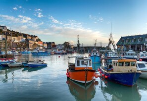 A harbor with various boats docked, a calm water surface, and buildings along the shore. - 2 Bed in St. Austell (oc-s31767) (Charlestown)
