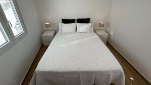 Ein Schlafzimmer mit einem Bett, zwei Nachttischen und zwei Lampen.