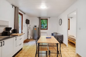 Una cocina compacta con una mesa de comedor, un refrigerador y un microondas.