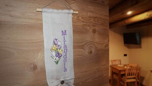 Ein Zimmer mit einer Holzwand und einem Banner mit floralem Muster sowie dem Namen "Miranda".