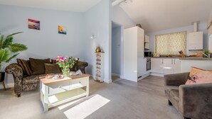 Een moderne woonkamer met een bank, salontafel en een boekenkast.