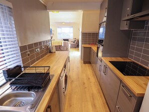 A modern kitchen with wooden countertops, stainless steel appliances, and a built-in oven. - Alford Road (Mablethorpe)